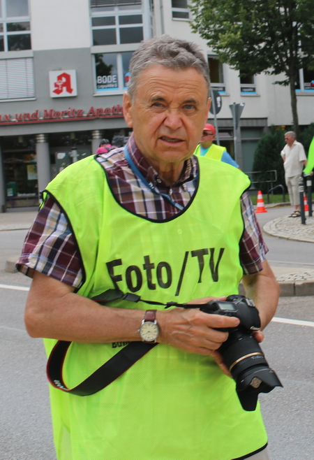 Reiner Buchheim mit Foto-TV-Weste und Kamera bei einem Radrennen